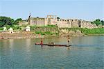 India, Madhya Pradesh, Burhanpur. Boatmen punt in the Tapti River beside the Shahi Qila, a medieval palace.