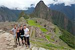 South America, Peru, Cusco, Machu Picchu. Inca trail hikers in front of the World Heritage listed Inka Historic Sanctuary of Machu Picchu with Huayna Picchu, Wayna Picchu, mountain behind. The site is situated in the Andes above the Urubamba valle