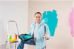 Mature Man Renovating his Home by Painting the Walls