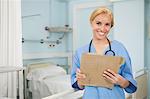 Nurse smiling at camera while holding a folder