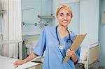 Nurse smiling while holding a folder