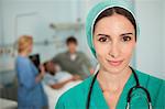 Nurse looking at camera next to a medical bed