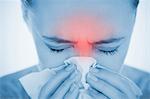 Woman blowing her nose with highlighted red sinus pain