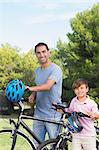 Smiling father and son with their bikes