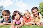 Cute brothers and sisters lying on a blanket