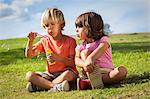 Brother and sister blowing bubbles