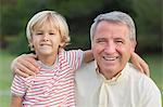 Portrait of happy grandfather with arm around grandson