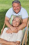 Portrait of older couple with woman in deck chair