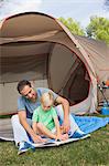 Father and son reading at the campsite