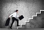 Businessman climbing the stairs to the top