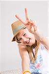 Portrait of Girl wearing Hat and making Peace Sign Gesture in Studio