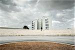 Man Walking Up Steps Towards Modern Building on Cloudy Overcast Day, Ostia Lido, Rome, Italy