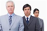 Mature businessman with his employees against a white background