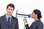 Close up of saleswoman with megaphone yelling at colleague against a white background