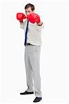Businessman with boxing gloves in offensive position against a white background