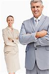 Cheerful business people with folded arms against white background