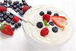 Bowl of cream with  different berries against a white background