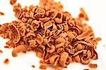 Many chocolate shavings against a white background