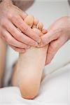Foot being touched by a chiropodist in a room
