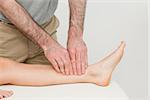 Doctor using his fingertips to massage a calf in a room