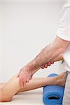 Podiatrist massaging the leg of his patient while standing in a room