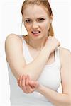 Blonde woman touching her painful elbow against white background