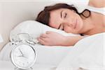 Brunette woman sleeping in the morning in her bedroom