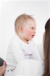 Happy child playing with her mother against a grey background