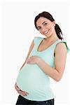 Young pregnant woman smiling at camera against white background