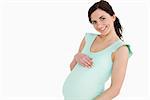 Pregnant woman smiling against white background