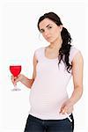 Pregnant brunette holding alcoholic drink and cigarette against white background