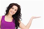 Beautiful student in purple top presenting with her palm against white background