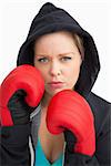 Woman showing her boxing gloves against white background