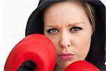 Woman protecting her face with boxing gloves against white background