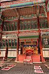 Geunjeongjeon Hall holds the royal throne room of the Gyeongbokgung Palace complexin Seoul Korea. The ornate decorations of the hall are painted in bright red and green colors.