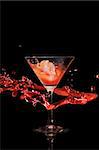 Splashing cocktail over dark background