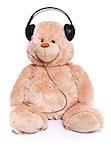 Teddy bear sitting with headset over white background
