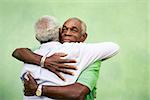 Active retired old men and leisure, two senior black brothers hugging outdoors