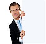Smiling business professional behind blank clipboard, isolated over white