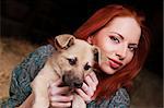 beautiful red-haired young woman playing with her dog