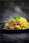 Italian cooking. Pasta spaghetti carbonara with ham, eggs and basil