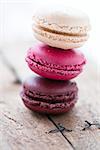 Closeup of stack of three different flavoured macaroons on wooden table