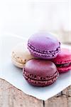 Closeup of four different flavoured macaroons on wooden table