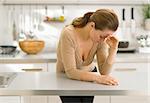 Stressed young woman in kitchen