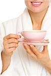 Closeup on woman in bathrobe with cup of coffee