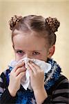 Little girl with the flu having red eyes - blowing nose