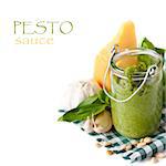 Homemade pesto sauce and ingredients on a white background.