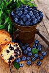 Muffins with blueberries in antique bronze mortar, rustic style