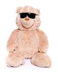 Teddy bear sitting over white background wearing black sunglasses