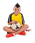 Teenage boy sitting with soccer ball, studio shot